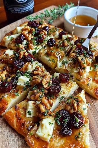 Crispy Flatbread with Brie, Cranberries & Toasted Walnuts RECIPE What You’ll Need: 1 flatbread or naan (store-bought or homemade) 5 oz brie, sliced or cubed 1/3 cup dried cranberries 1/3 cup toasted walnuts (halves or rough chopped) 1–2 tsp fresh thyme leaves Olive oil, for brushing Salt & cracked black pepper to taste For the hot honey drizzle: 1/4 cup honey 1/2 tsp red pepper flakes (adjust heat to your liking) 🔥 How to Make It: Preheat oven to 400°F (200°C). Line a baking sheet with parchmen