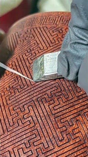 A craftsman demonstrates the technique of inlaying silver wire on wooden crafts