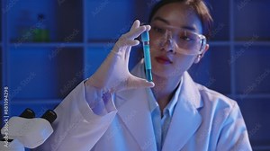 Scientist in lab coat and safety goggles inspecting test tubes with liquid samples in a modern laboratory. Focus on analysis and research in a sterile environment