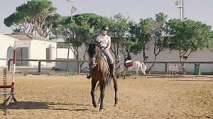 4K video of a young rider performing equestrian dressage exercises at a riding school