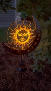 🌙✨ Light up your garden with our enchanting Sun/Moon/Stars Solar Stake! 🌟 This celestial-inspired garden decoration features a glowing sun centerpiece surrounded by the moon and stars, all illuminated by captivating Amber-colored flashing LED lights at night. Add a touch of magic to your outdoor space with this mesmerizing stake that brings a celestial glow to your garden. 🌌🌿 #SolarStake #CelestialLights #GardenDecor | Baker's Village Garden Center & Gift Shoppe