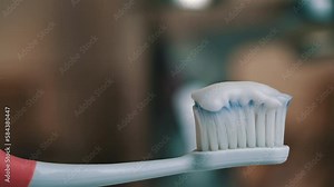 Toothpaste climbs out of the tube onto the toothbrush close-up. Apply toothpaste to the brush. Morning brushing of teeth. Take care of your teeth. Daily hygiene.