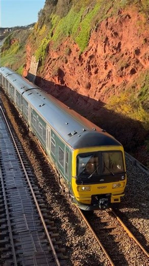 GWR class 166 accelerates down the seawall at Rockstone Bridge. Paignton to Exmouth service 166207