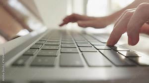 Youth and technology: A teenager plays computer games by pressing laptop keys, which develops his skills and abilities. Children's play addiction. Close-up shows a hand interacting with the keyboard,