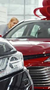 Cheerful woman exploring new cars at a vibrant dealership showroom