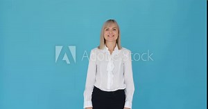 Woman making a peace sign gesture with her fingers on a serene blue background. The peace sign gesture, with the V-shaped fingers, symbolizes peace and harmony.