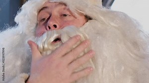 Close up of Santa Claus napping on a chair at home. Santa Claus is tired after a hard day's work.