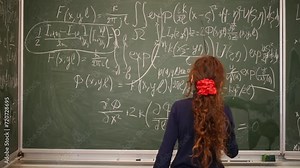 Girl standing at blackboard and reading with pointers equations.