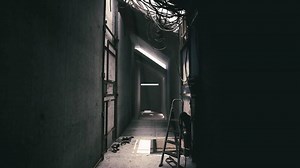 Exploring a dark hallway in an industrial building filled with cables