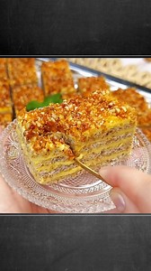 Cu 200g de unt faci un platou intreg! Reteta de prajitura Krantz cu blat cu nuca si crema fina de vanilie si nuca caramelizata pe deasupra! Ingrediente (20 portii): Blat: • 12 albusuri (~400 g) • Optional o lingura otet • 250 g zahar • 200 g nuca macinata fin (nu trebuie sa fie de loc ranceda sau amara) • 100g faina Crema: • 6 galbenusuri • 250 ml lapte 3.5% grasime • 20 g amidon • 125 de zahar • 200 g unt cu minim 80% grasime, la temperatura camerei • 2 lingurite de extract de vanilie Pralina d