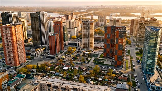 A modern city rising along a river in Siberia