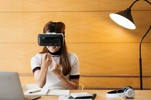 Download Woman wearing virtual reality goggles standing in a office. VR glasses. 360 degrees. Virtual reality headset. VR game. Wearing virtual reality goggles. Smartphone with VR. Virtual reality video. for free