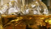 Pouring whiskey on ice close up