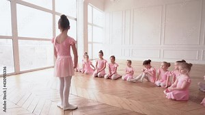 Girls dancers in ballet school learns to dance. Little Ballerinas in training in pink dancing suit. Children's ballet school. School of ballet.