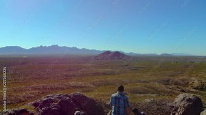 Hikers Enjoy View On Top Fly Over Aerial. aerial view flying over people on top of a rock formation in the middle of southwest desert scene