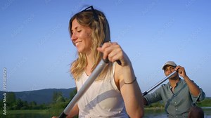 Happy couple enjoying a summer canoe ride on the lake, relaxing surrounded by beautiful green nature, close up shot. Canoeing trip concepts.
