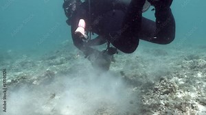 Scuba Diver Cleaning Plastic Trash Under The Ocean. Water Pollution Cleanup. underwater
