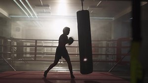 Kickboxing, woman fighter trains his punches, beats a punching bag, training day in the boxing gym, strength fit body, the girl strikes fast.