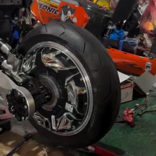 A few weeks ago, one commenter mentioned that tires can grow during use. Though that effect is generally pretty small for street-tires with their thick-walled construction to survive road use, racing motorcycle tires tend to be thinner (to shed heat better) and exhibit more pronounced growth. Mick Doohan crashed hard in 1992 when his rear tire grew enough to impinge on the swingarm. This video shows a tech checking the dynamic balance for a racing motorcycle wheel/tire assembly, I think. We see 