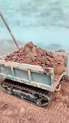 Demonstration of a Track Loader Bucket Loading and Dumping Soil on a Construction Site