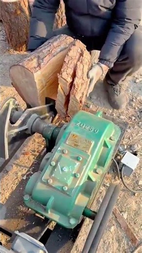 splitting a large wood log into smaller pieces using a mechanical log splitter machine