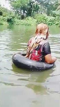 Beautiful hair girl washing her hair in the ponds water