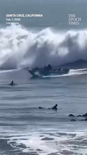 Speeding past surfers and large waves, the boat was engulfed by the water and knocked on its side, capsizing. | The Epoch Times
