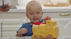 mother helps child do inhalation at home, little boy using nebulizer