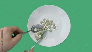 Eating the tablets from a dish on green screen slow motion - medicine concept Stock Video