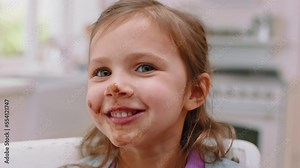 Messy, chocolate and face of girl in kitchen for food, candy and breakfast spread. Happiness, dessert and comic with sweets on mouth of child at home eating for sugar, cake and cocoa snack