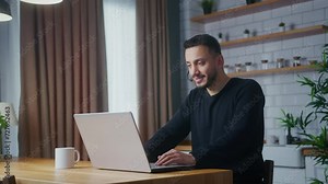 Man wear wireless headset having video conference call on laptop computer talk by webcam in online chat in kitchen at home. Customer support service, distance online teaching concept