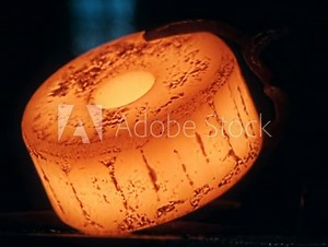 Hot Orange Metal Wheel gets from Induction Foundry Furnace. Black Background. Forging Room, Workshop. Red Molten Steel. Steel casting. Hot metal. Heat. Danger. Heavy industry. Close up, slow motion.