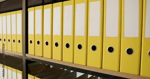 Shelf full of identical yellow office folders. Documentation archive and storage of business documents