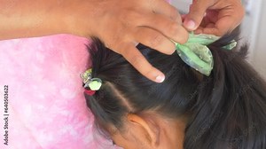 Mother makes her daughter's hair and braids.