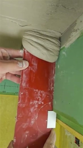 Applying thick joint compound or plaster to an interior wall corner with a spatula