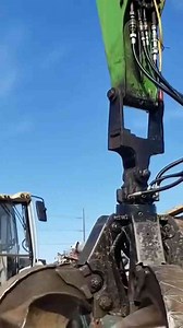 Scrap Yard Workers Handling Appliances with Heavy Machinery