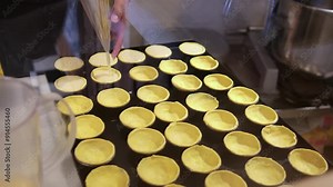 The process of making Pastel de nata - Spanish dessert made from puff pastry. Making small Spanish pastries Pastel de Belem - putting the dough into baking moulds.