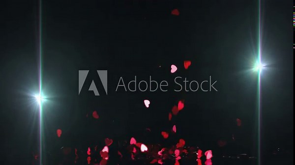 Heart confetti cascading from top release, forming glinting pile under teal lights for design