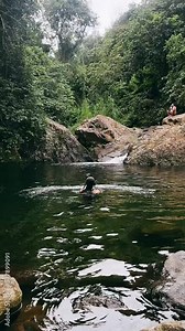 natural swimming hole, natural spring water, beautiful woman swimming in waterhole, beautiful view of waterfalls, woman walking towards waterfalls, waterfalls,