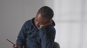Free stock video - Studio shot of boy at table concentrating on writing in school book
