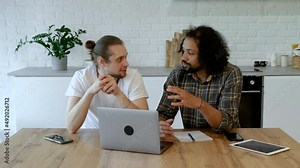 Two Young Male Freelancers Are Working At Home on an Online Project. Creative businessmen having informal meeting in co-working space