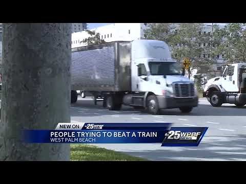 Video shows people trying to beat a train