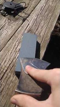 Sharpening an ax with a wet stone.