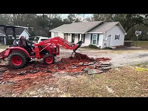 Using tractor forks like a pry bar to pull up hugh Roots Under an Asphalt Driveway
