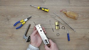 New narrow mortise lock. A man inspects a lock before installation. View from above.