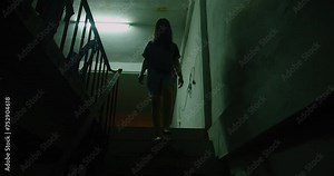 A woman ghost is walking down a dark stairwell. The image has a moody scary horror creepy darkness and eerie atmosphere, Halloween holidays concept