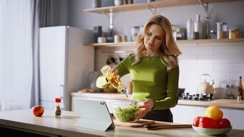 clip-4032268019-cooking-woman-adding-oil-mixing-vegetables-apartment