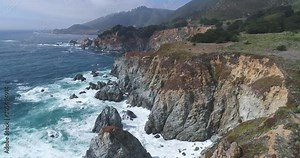 Flight over of rocky coastline. Ocean shore, waves crashing cliffs, California
