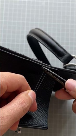 Hand-stitched minimalist black leather handbag handmade crafting process.