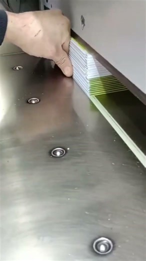Process of cutting paper stacks using a large paper cutter machine.
